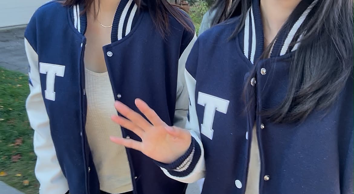 Members in UofT varsity jackets waving
